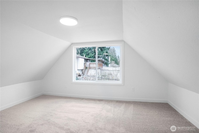 additional living space with carpet flooring, baseboards, and vaulted ceiling