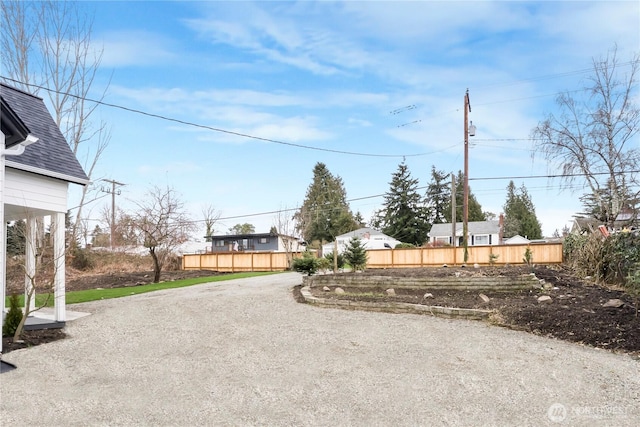 view of yard with fence and driveway