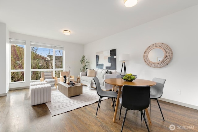 dining space with baseboards and wood finished floors