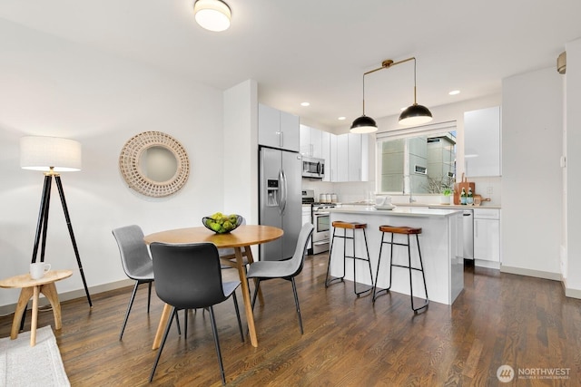 dining area with dark wood-type flooring, recessed lighting, and baseboards