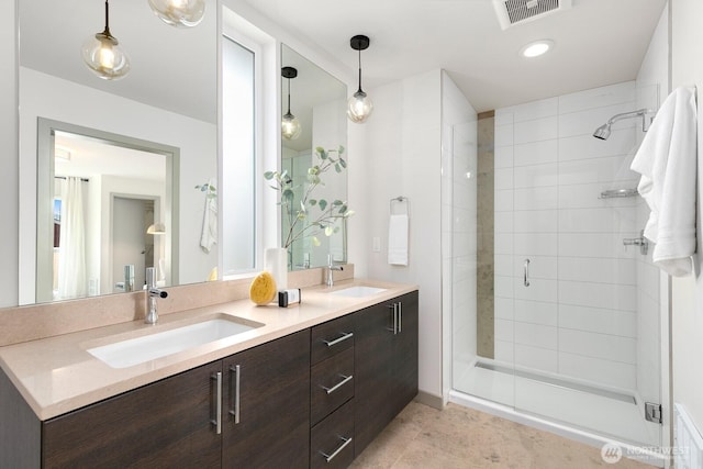 bathroom with a sink, visible vents, double vanity, and a shower stall