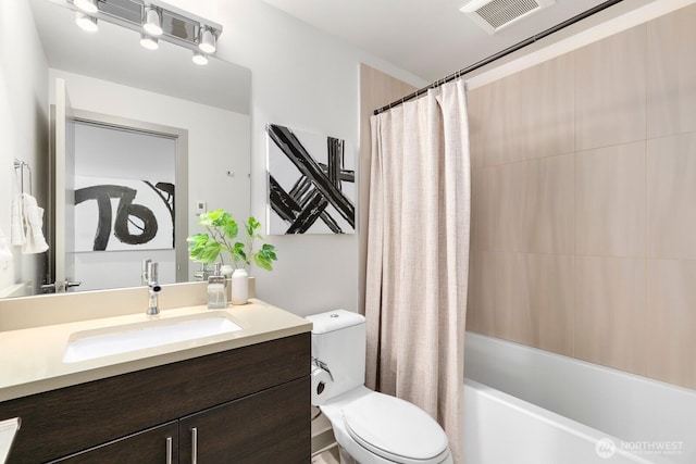 bathroom featuring visible vents, toilet, vanity, and shower / tub combo