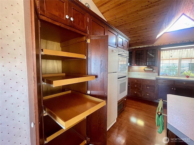 kitchen featuring lofted ceiling, wood ceiling, dark wood-style flooring, and wallpapered walls