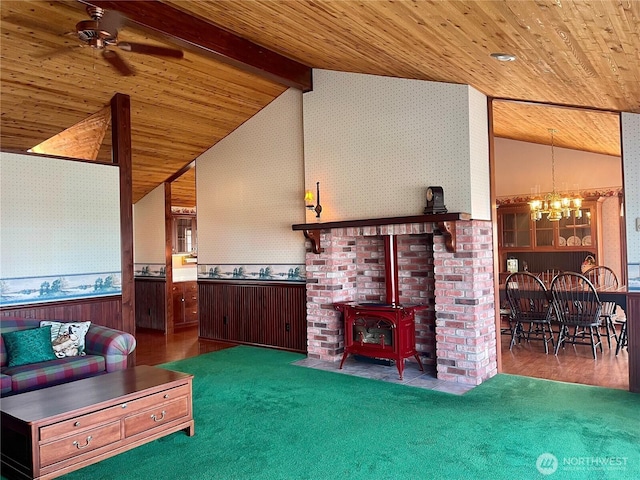 living area with beamed ceiling, wooden ceiling, a wood stove, and wallpapered walls