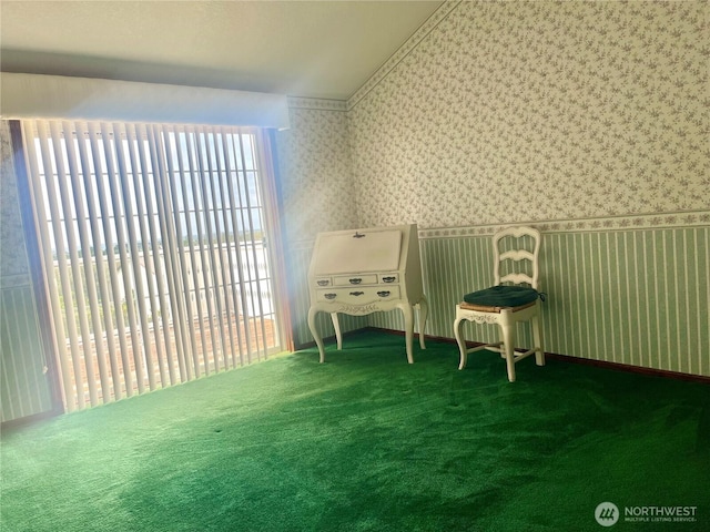 sitting room with a healthy amount of sunlight, vaulted ceiling, and wallpapered walls