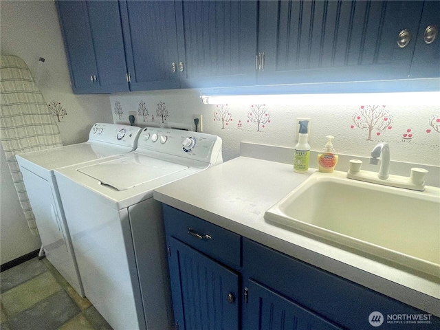 washroom featuring separate washer and dryer, cabinet space, and a sink