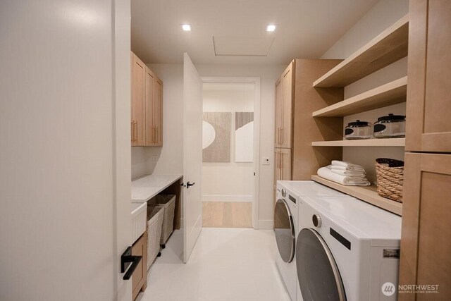 clothes washing area featuring cabinet space, attic access, and separate washer and dryer