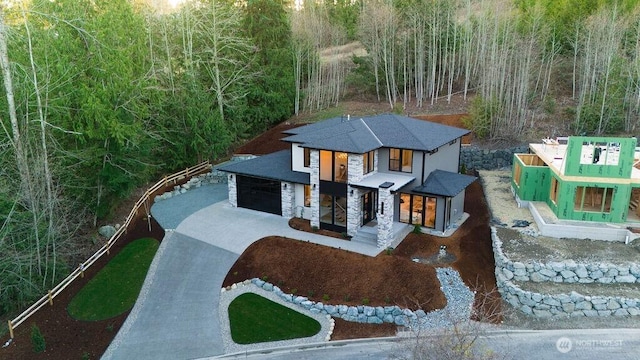 view of front facade with stone siding, concrete driveway, and a garage