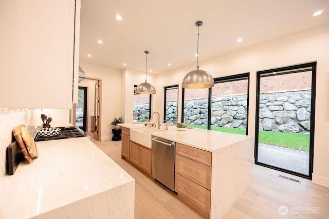 kitchen with light brown cabinetry, a healthy amount of sunlight, appliances with stainless steel finishes, and a sink