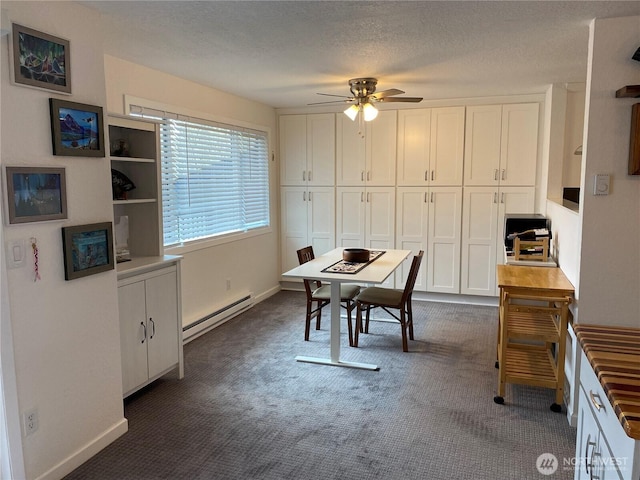 office area featuring a baseboard heating unit, a ceiling fan, dark carpet, and a textured ceiling