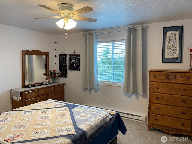 bedroom featuring carpet flooring, a textured ceiling, a baseboard heating unit, and a ceiling fan