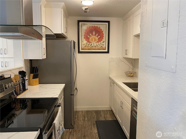 kitchen with dark wood-style flooring, wall chimney exhaust hood, white cabinets, and stainless steel range with electric cooktop