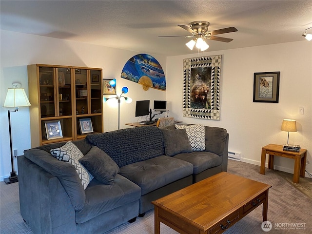 living room featuring baseboards, ceiling fan, baseboard heating, carpet flooring, and a textured ceiling