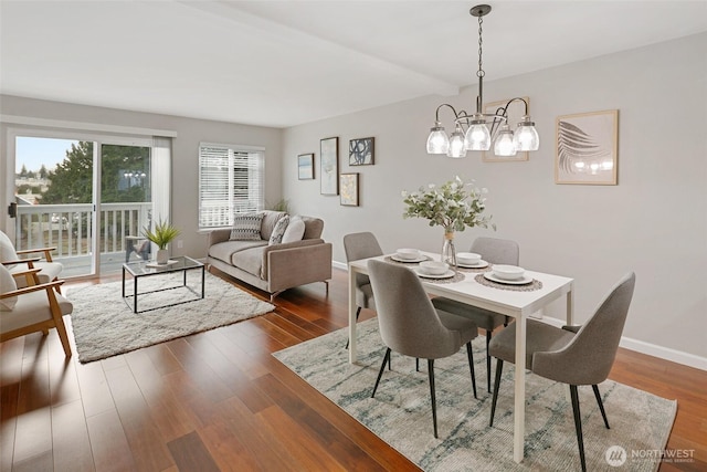 dining room featuring dark wood-style floors, a notable chandelier, beamed ceiling, and baseboards
