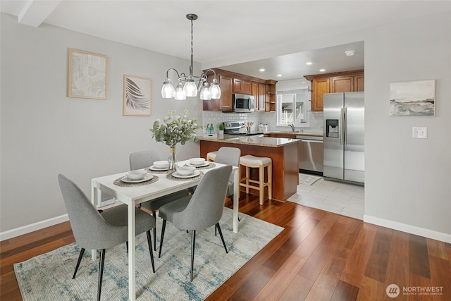 dining area with a notable chandelier, recessed lighting, baseboards, and light wood-style floors