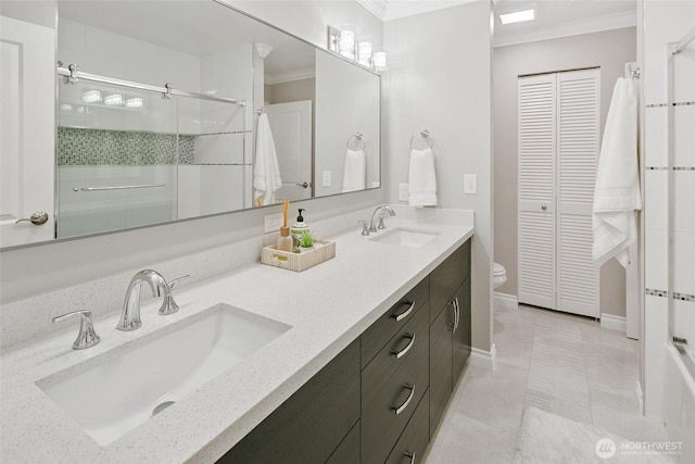 full bathroom featuring a shower stall, ornamental molding, a closet, and a sink