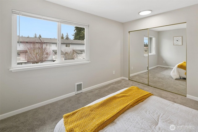 bedroom with a closet, visible vents, multiple windows, and baseboards