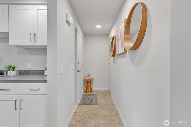 hall with recessed lighting and baseboards