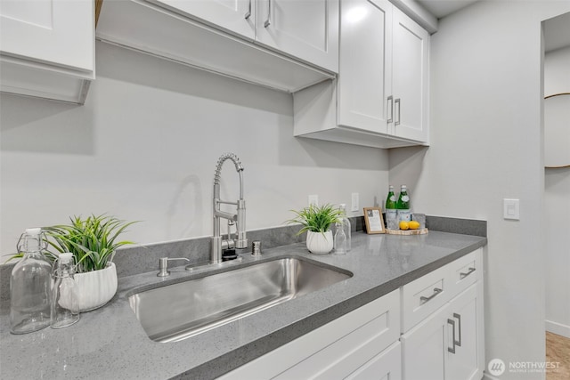 kitchen with white cabinetry and a sink