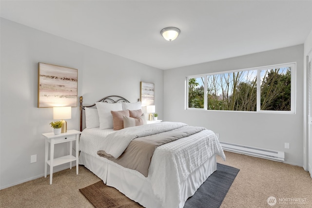 bedroom featuring a baseboard heating unit, baseboards, and carpet floors