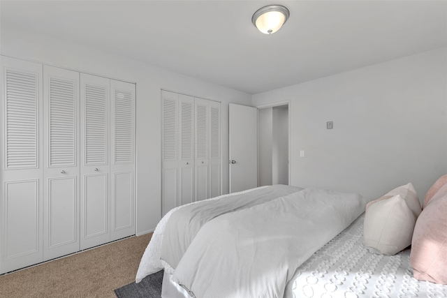 carpeted bedroom featuring multiple closets