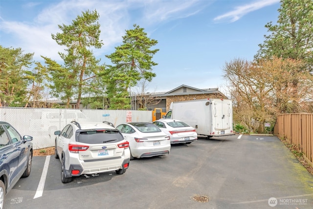 view of front of house with uncovered parking and fence