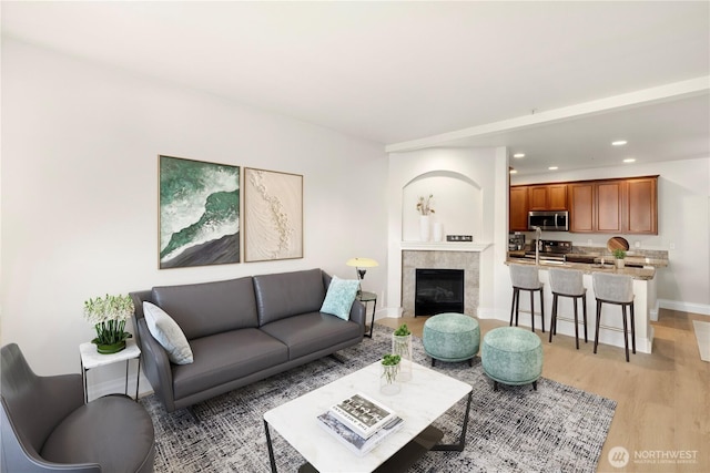 12601 172nd St E Unit Jj102, Puyallup, WA 98374 - living room featuring light wood-style floors, baseboards, recessed lighting, and a tiled fireplace