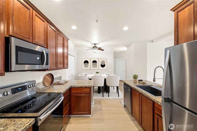 12601 172nd St E Unit Jj102, Puyallup, WA 98374 - kitchen featuring stainless steel appliances, a sink, ceiling fan, a peninsula, and light wood-type flooring