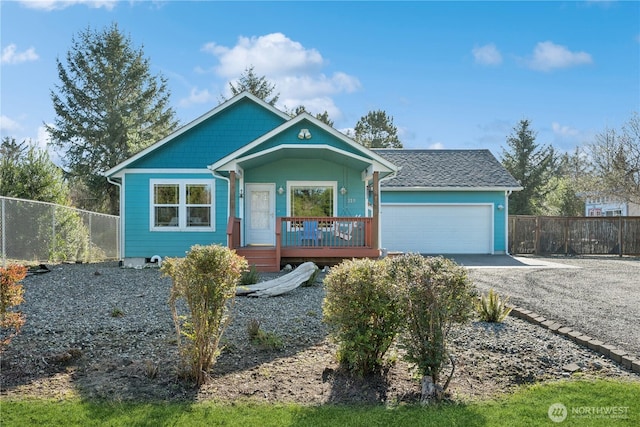 view of front of property featuring a garage, a porch, driveway, and fence