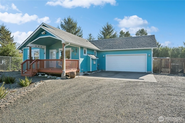 view of front of home with driveway, a shingled roof, a garage, and fence