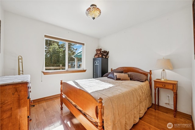 bedroom featuring baseboards and wood finished floors