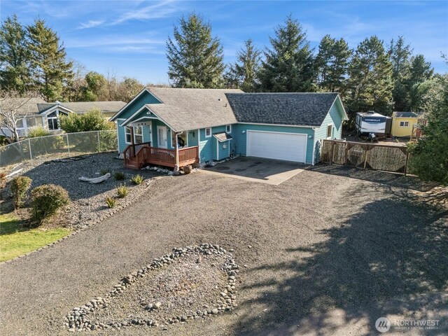 ranch-style home featuring a shingled roof, fence, dirt driveway, a deck, and a garage