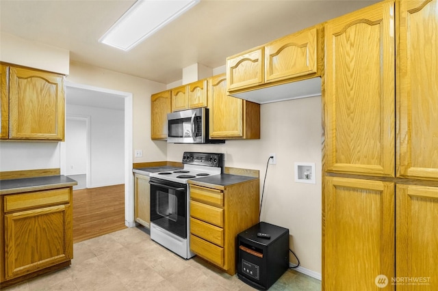 kitchen featuring dark countertops, stainless steel microwave, and electric range oven