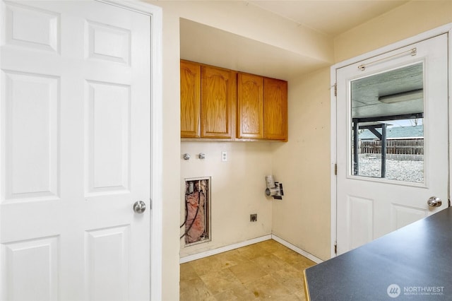 clothes washing area featuring electric dryer hookup, baseboards, and cabinet space