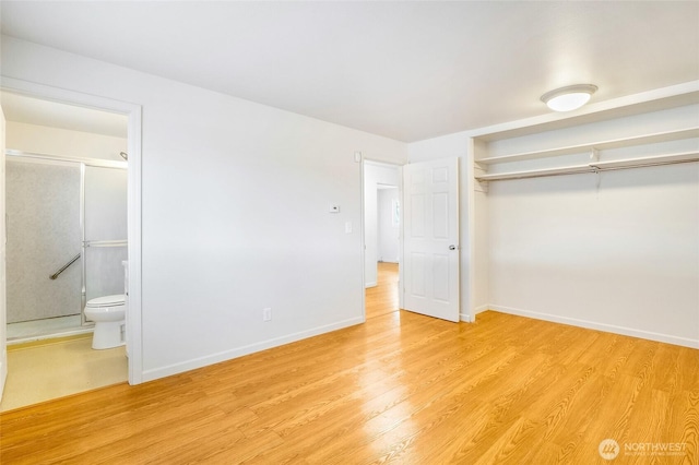 unfurnished bedroom with a closet, light wood-style flooring, ensuite bathroom, and baseboards