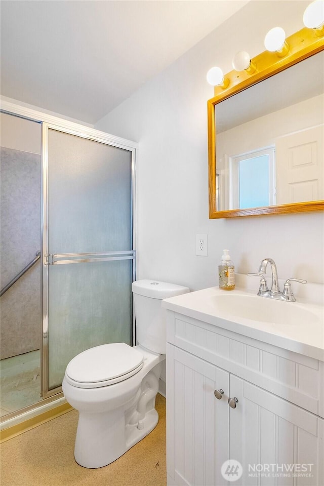 full bathroom featuring vanity, toilet, and a shower stall