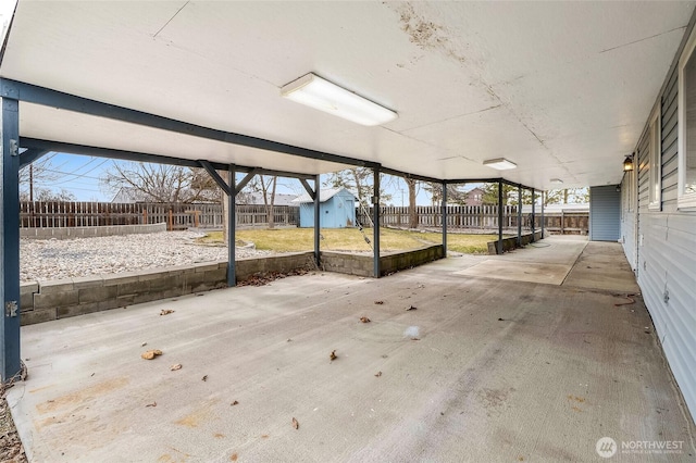 view of patio with an outbuilding, a storage unit, and a fenced backyard