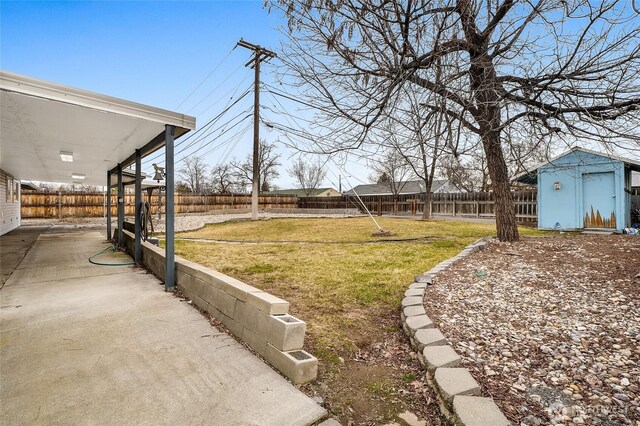 view of yard with a storage unit, an outbuilding, and a fenced backyard