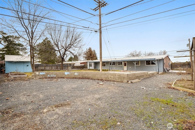 view of front facade with an outdoor structure, a shed, and fence