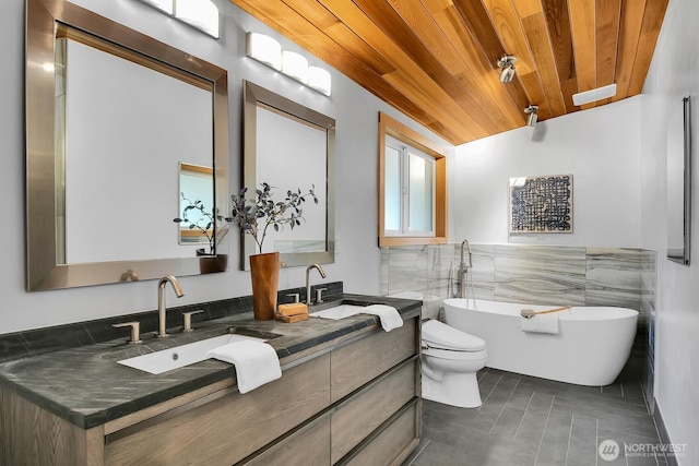 full bath with a sink, a freestanding tub, wood ceiling, and double vanity