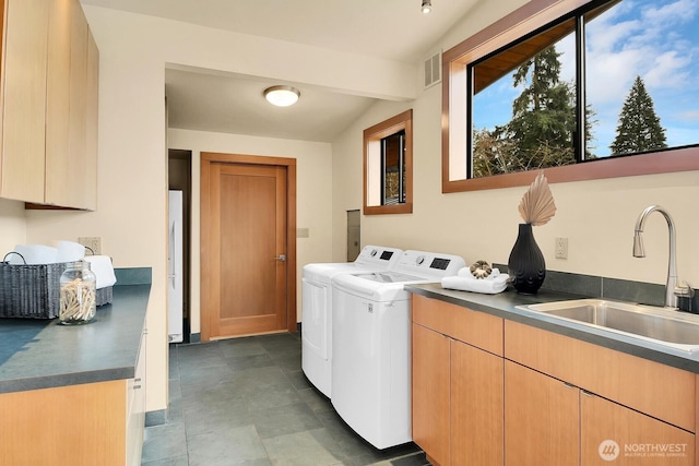 washroom featuring cabinet space, visible vents, washing machine and dryer, and a sink