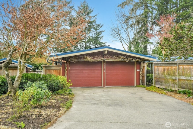 garage featuring fence and driveway