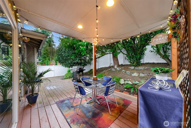 wooden terrace featuring a grill and a fenced backyard