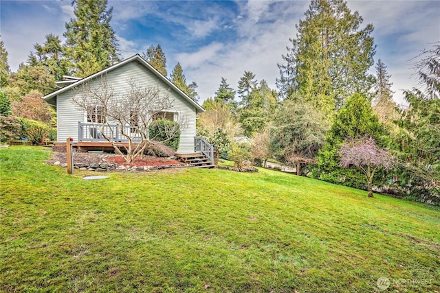 back of house with a deck and a yard