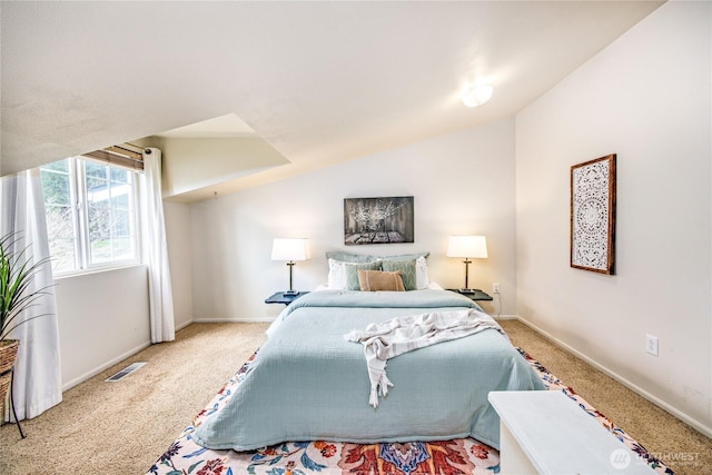 bedroom with vaulted ceiling, carpet flooring, baseboards, and visible vents