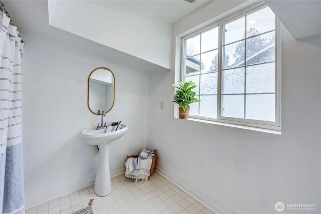 bathroom featuring a shower with shower curtain and baseboards