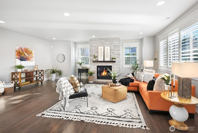 living area featuring a fireplace, recessed lighting, wood finished floors, and visible vents