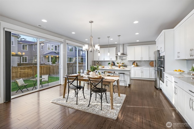 dining area with visible vents, recessed lighting, dark wood-type flooring, and an inviting chandelier