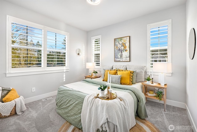 bedroom with multiple windows, baseboards, visible vents, and carpet floors