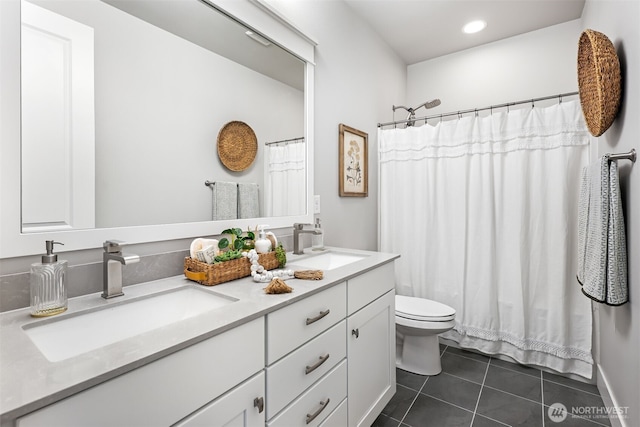 full bath with tile patterned flooring, double vanity, toilet, and a sink